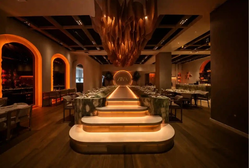The dining room at ZIVA restaurant, glowing amber lights over dark wood tables